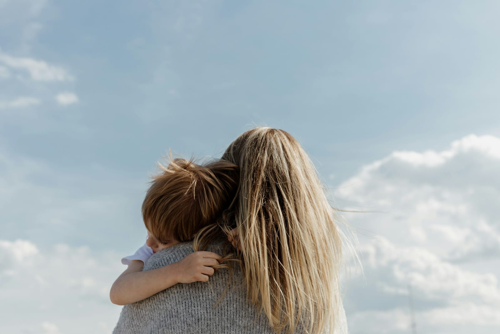 Twee mensen kijken samen op een telefoon, bij de review van Alleenstaande Mama’s